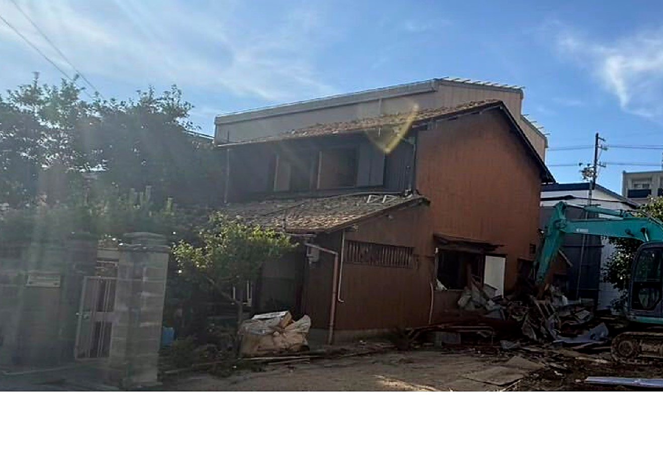 解体中の木造住宅、重機による解体作業の様子